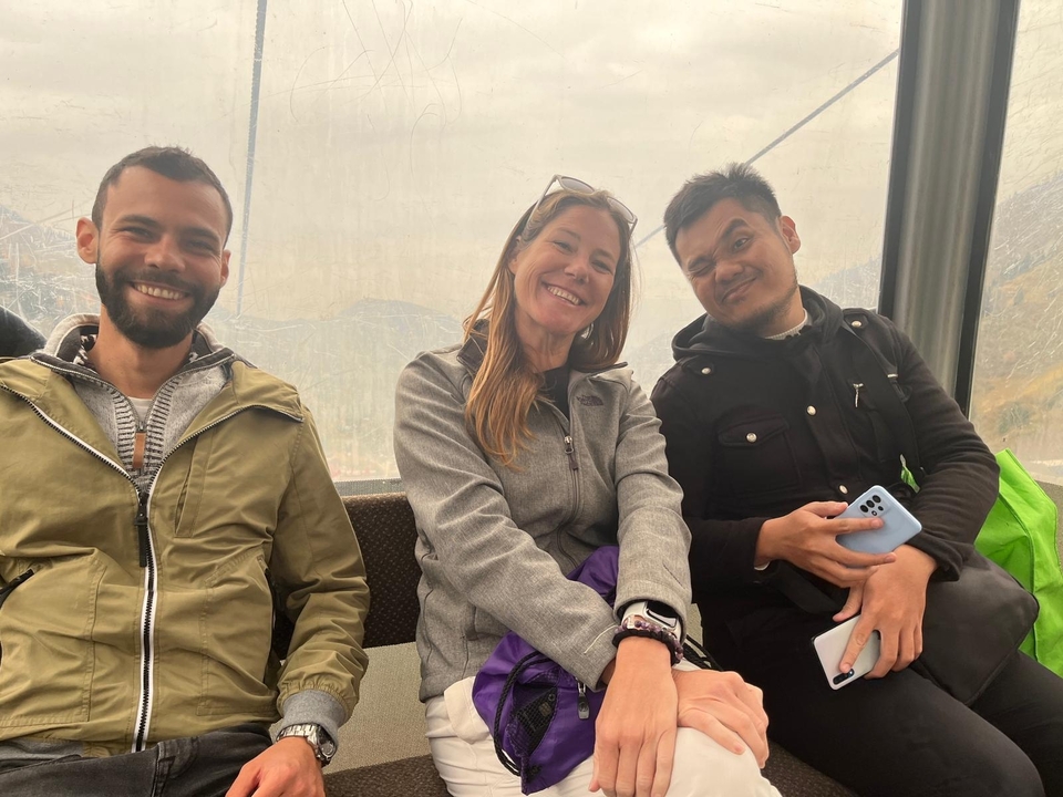 Tres personas sonriendo dentro de un teleférico.