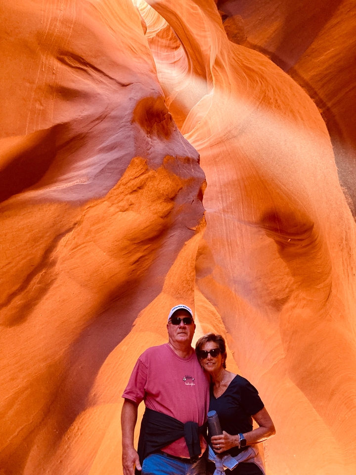 Gros plan d'une personne debout contre des formations rocheuses oranges.