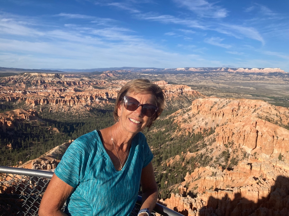 Femme souriante avec une vue panoramique de Bryce Canyon.