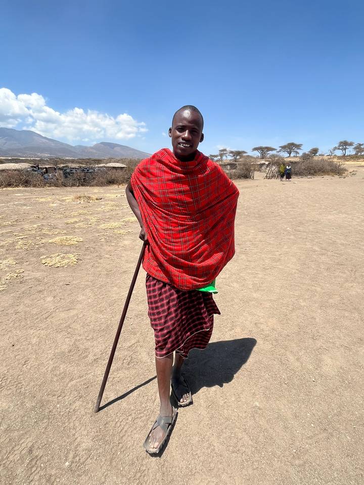 Personne en vêtements traditionnels se tenant dans un espace ouvert.