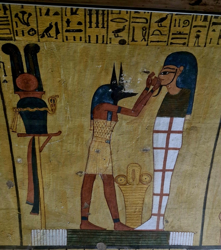 Peinture murale de l'Égypte antique représentant des dieux et des symboles.