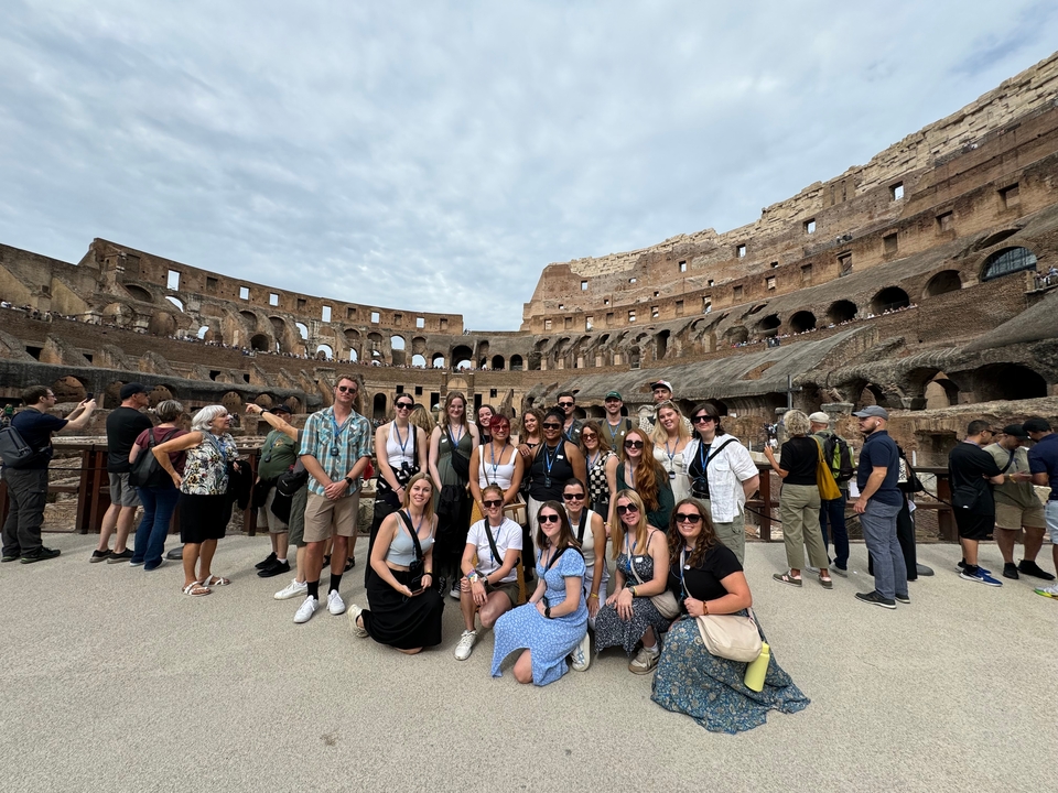 Groupe à l'intérieur du Colisée avec de grandes arches visibles.