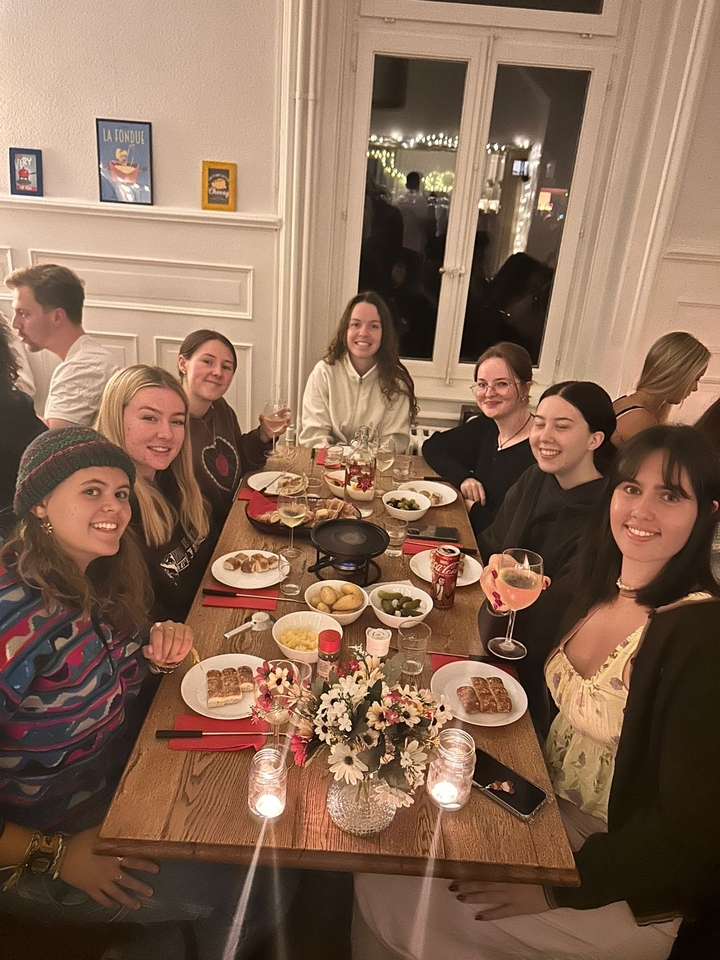 Groupe de personnes souriantes autour d'une table de dîner.