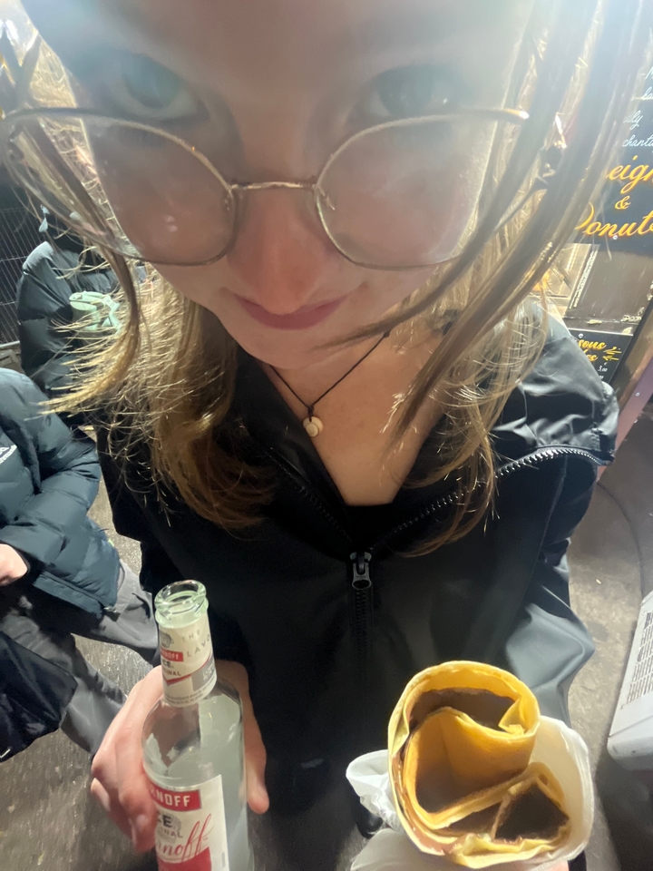 Haut du corps d'une personne tenant une boisson.