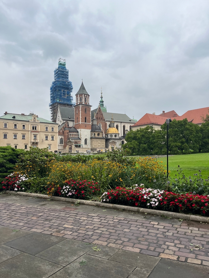 Bâtiment historique avec échafaudage et décoré de fleurs.