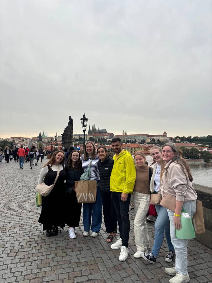 Groupe de personnes posant sur un pont historique.
