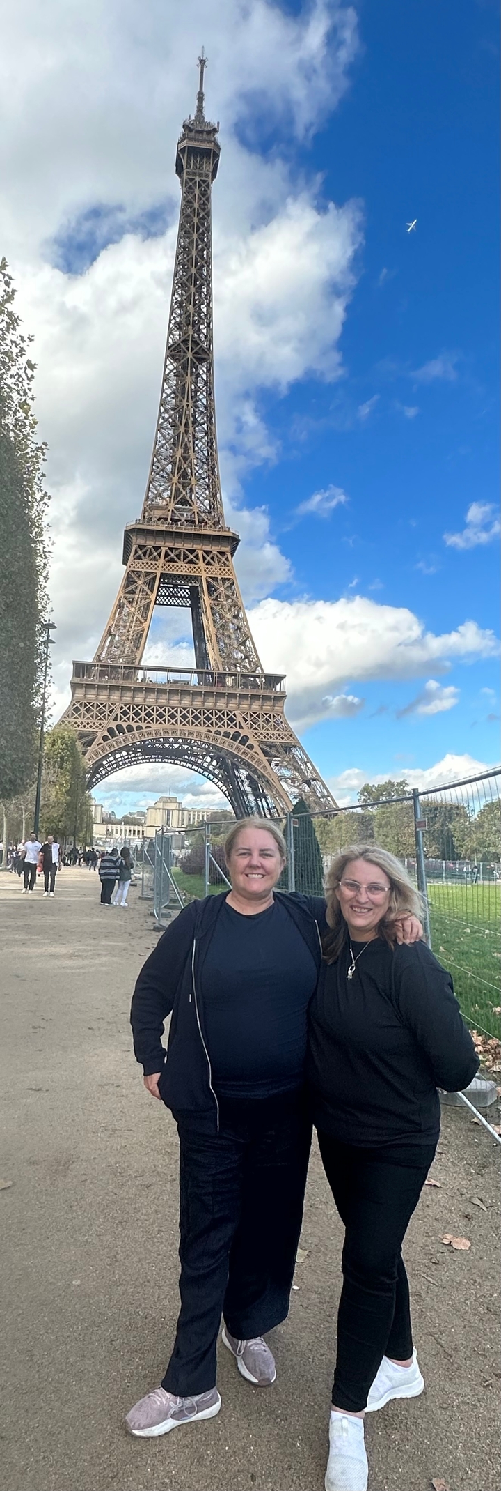 Deux personnes debout devant la tour Eiffel.