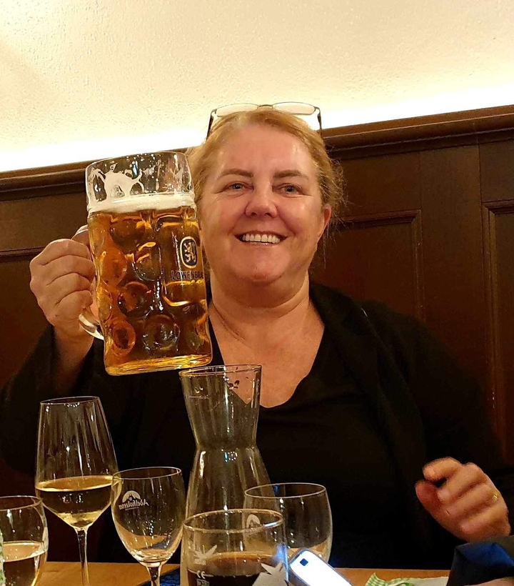 Une personne tenant une grande chope de bière dans un restaurant.