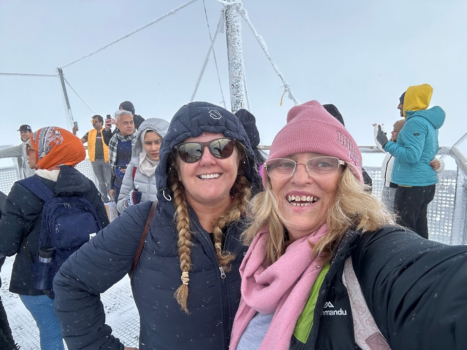 Groupe de personnes sur une plateforme d'observation enneigée.