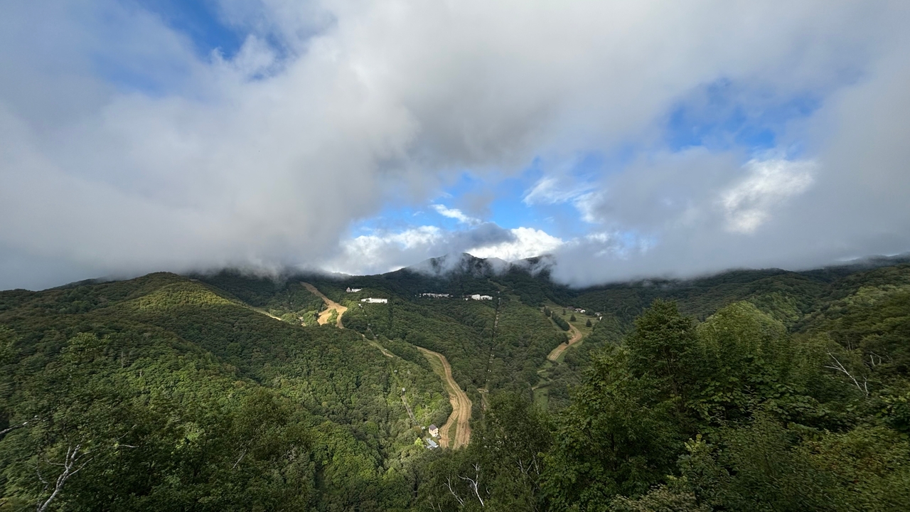 Paysage montagneux partiellement couvert de nuages.