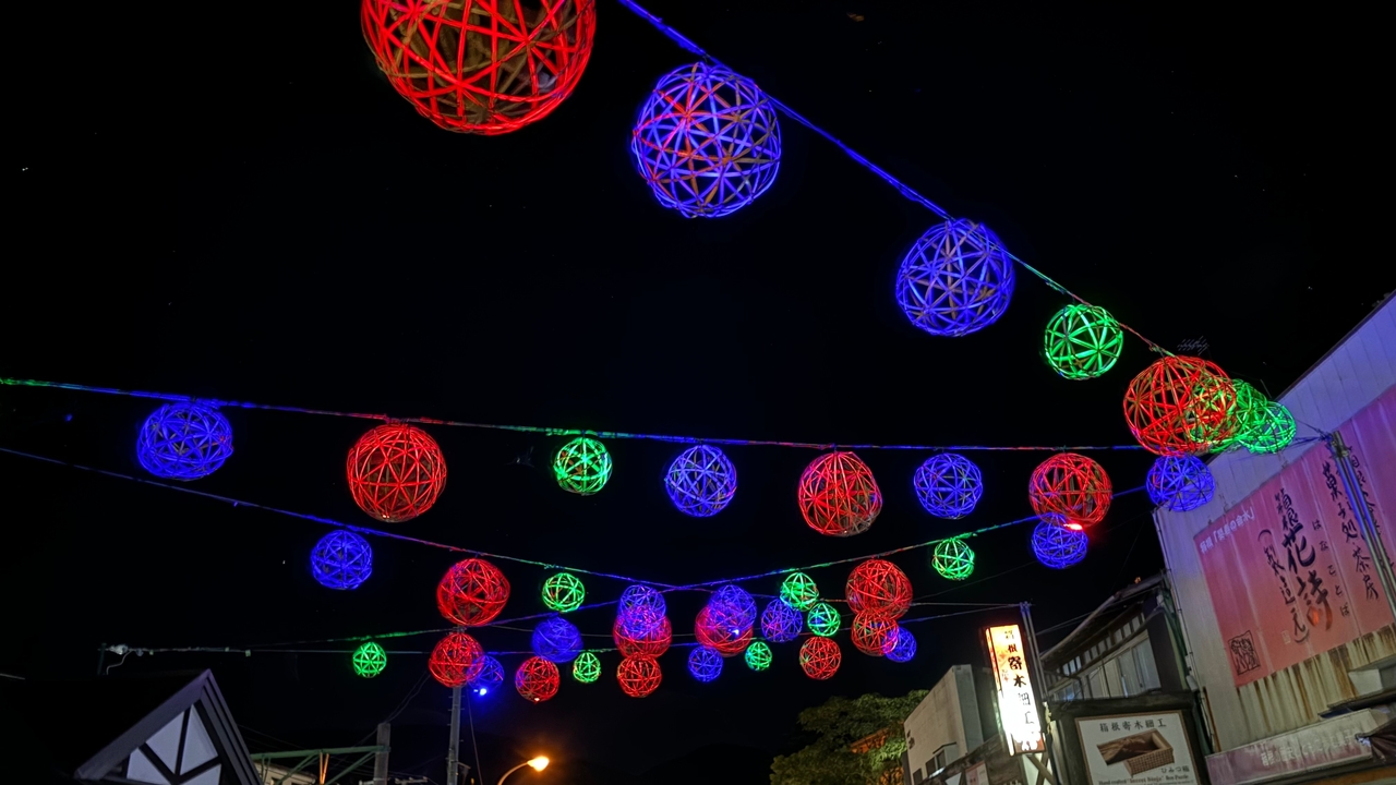 Sphères décoratives colorées suspendues la nuit.