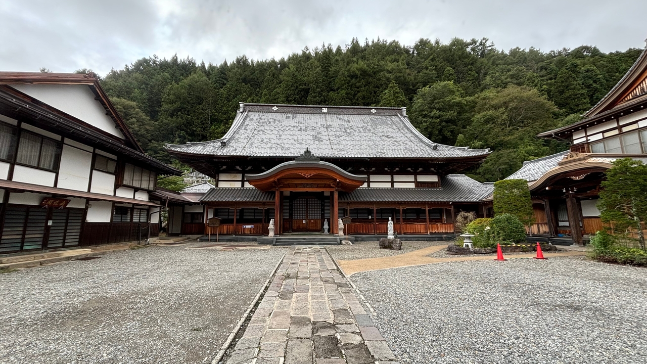 Petit temple japonais traditionnel entouré d'arbres.