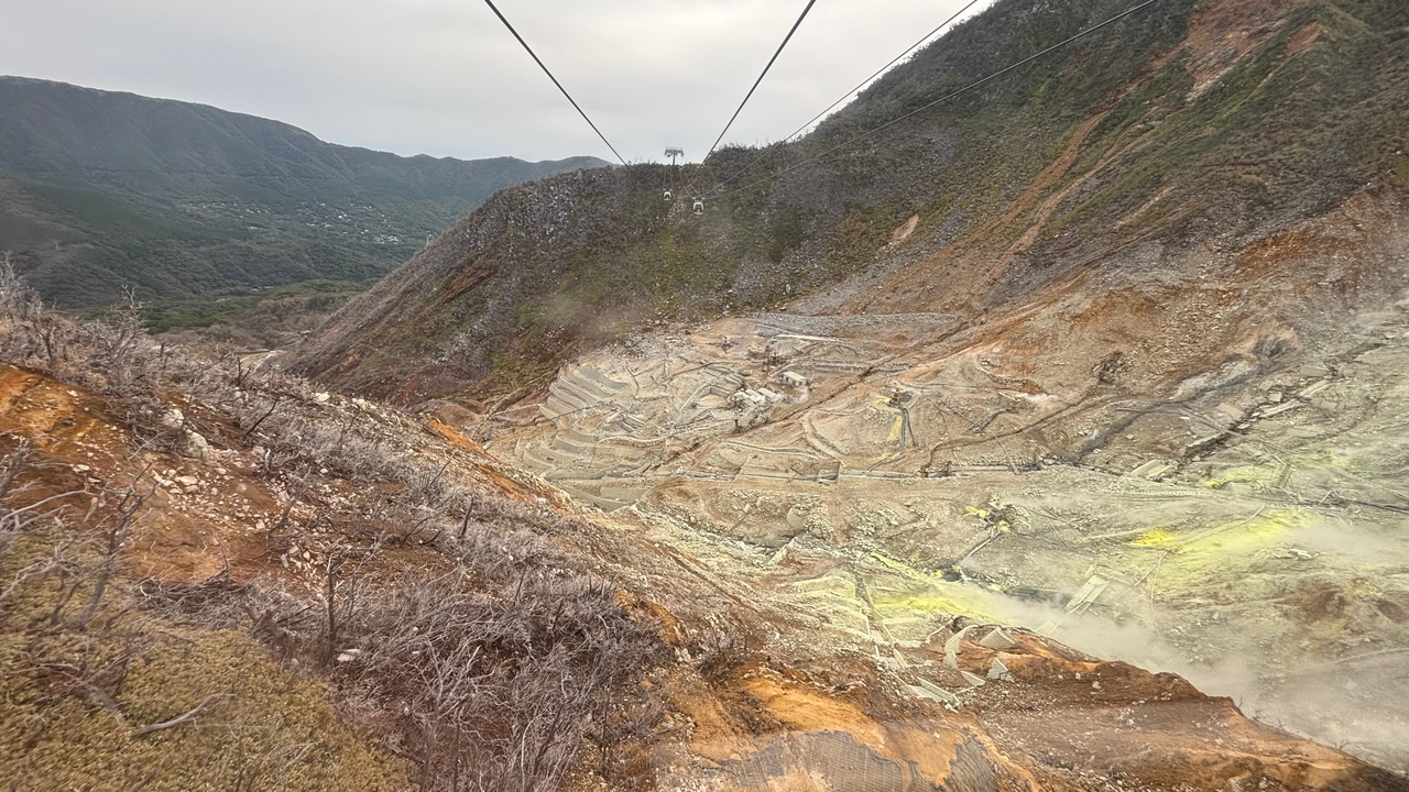 Vue aérienne d'une montagne accidentée avec activité géothermique.