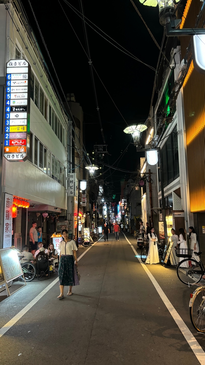 Rue animée de la ville la nuit avec des gens et des magasins.