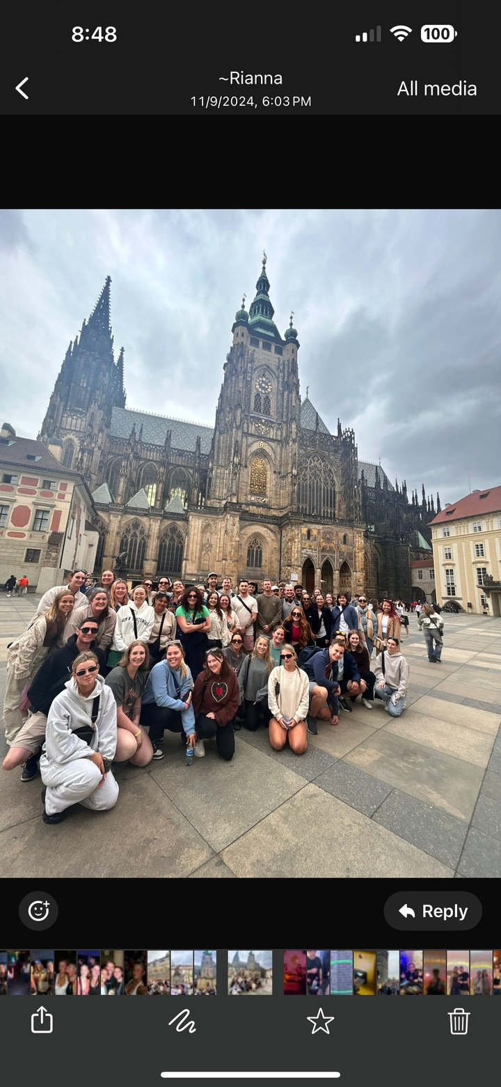 Grand groupe de personnes posant devant une cathédrale historique.