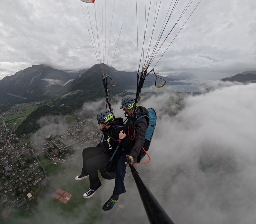 Deux personnes faisant du parapente au-dessus d'un paysage montagneux.