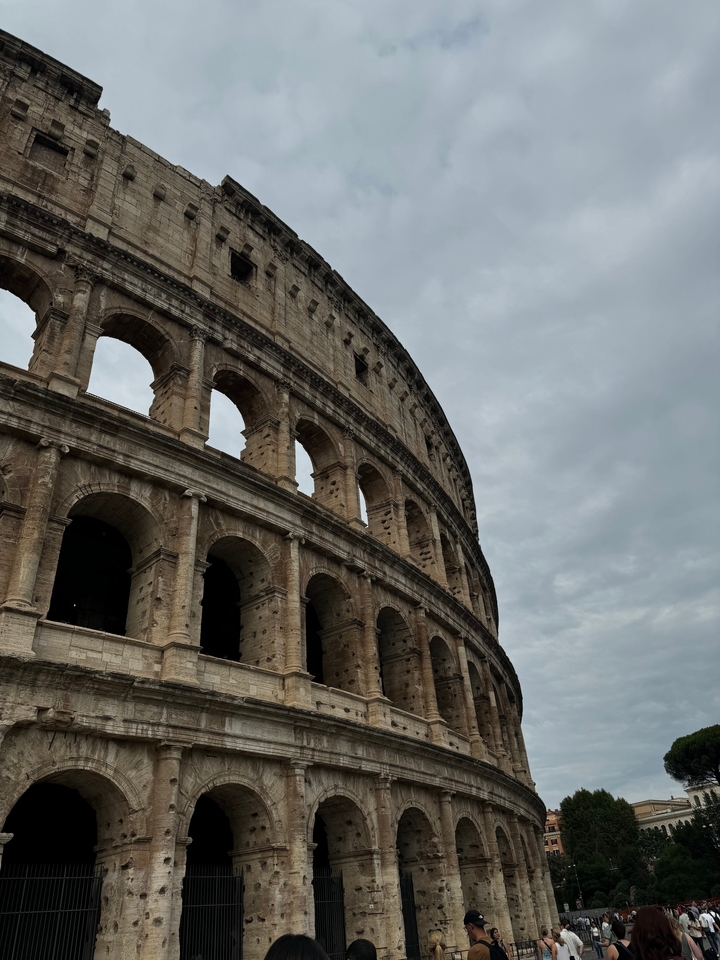 Vue rapprochée du Colisée sur un ciel nuageux.