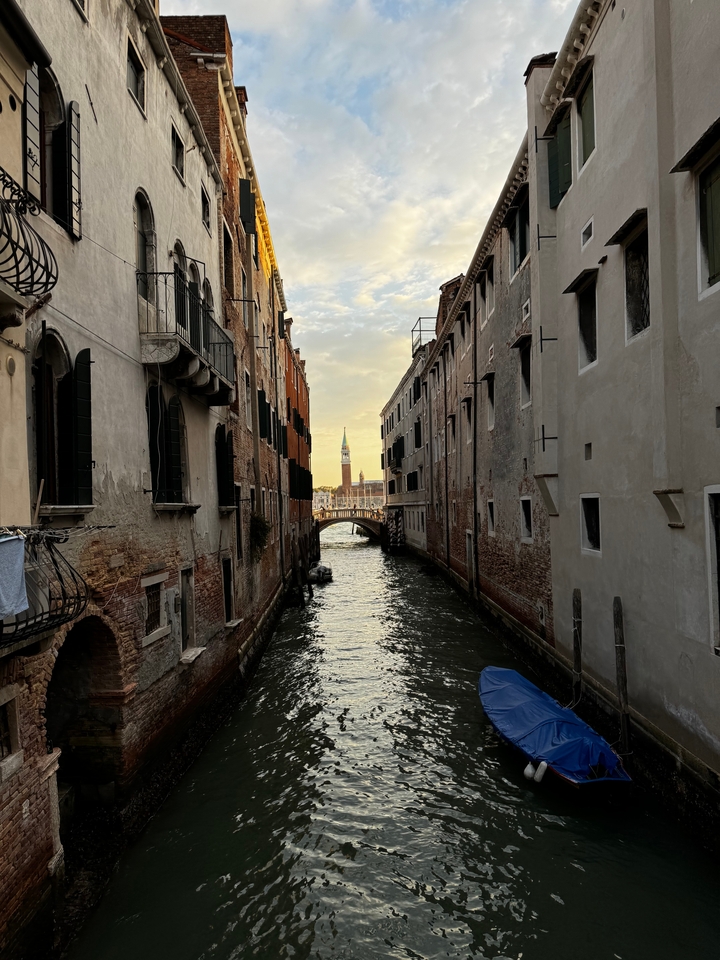 Canal étroit avec vue sur un clocher au loin à Venise.