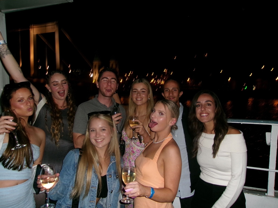 Des gens profitant d'une promenade en bateau nocturne avec les lumières de la ville en arrière-plan.