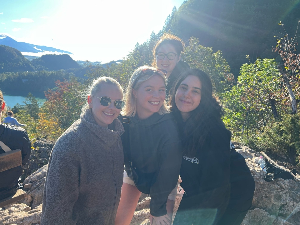 Quatre femmes posant avec un arrière-plan montagneux pittoresque.