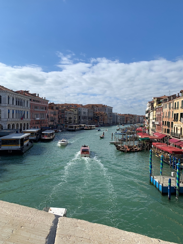 Canal animé avec des bateaux et des bâtiments colorés le long des rives.
