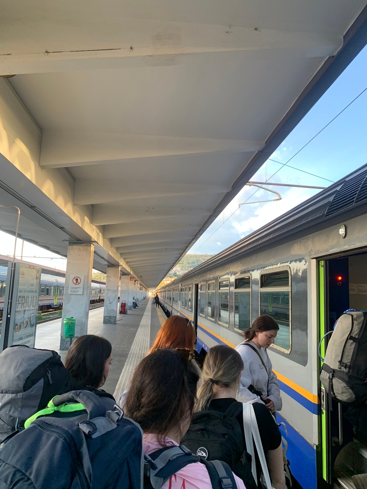 Des gens debout sur un quai à côté d'un train dans une gare.