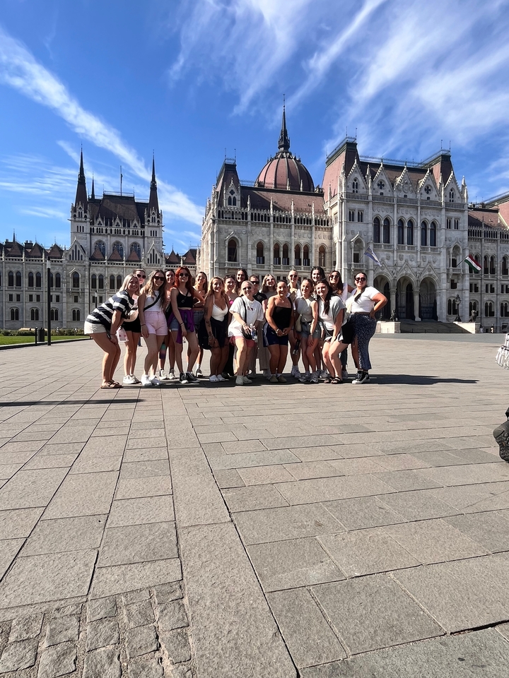 Grand groupe posant devant un bâtiment historique important.