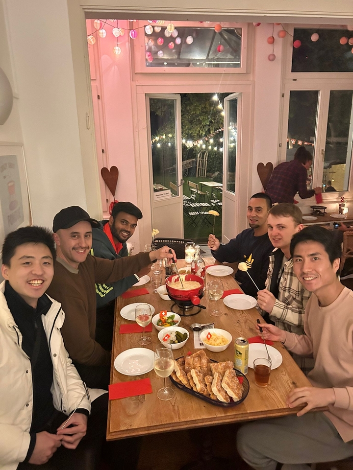 Groupe d'amis profitant d'un repas de fondue au fromage à l'intérieur.