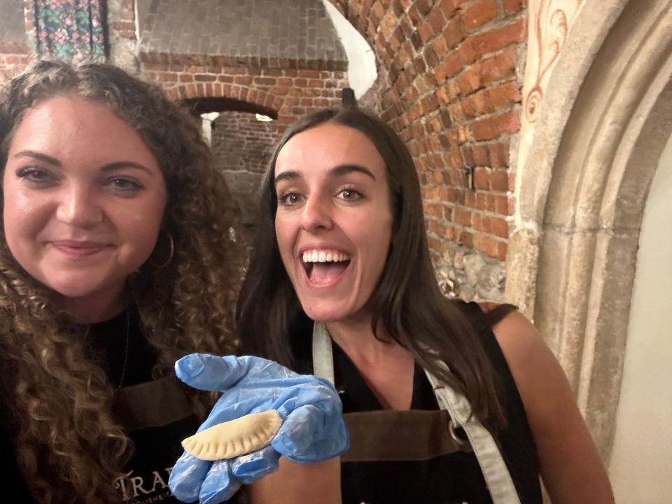 Deux personnes souriantes à l'intérieur d'un intérieur en briques.