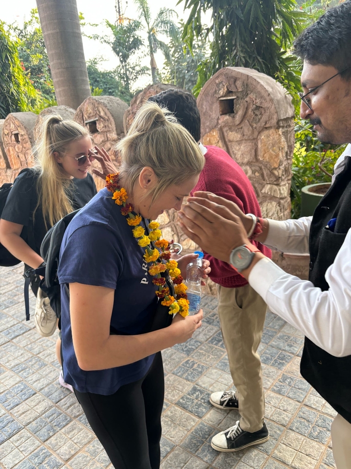 Personne accueillie avec une guirlande de fleurs.