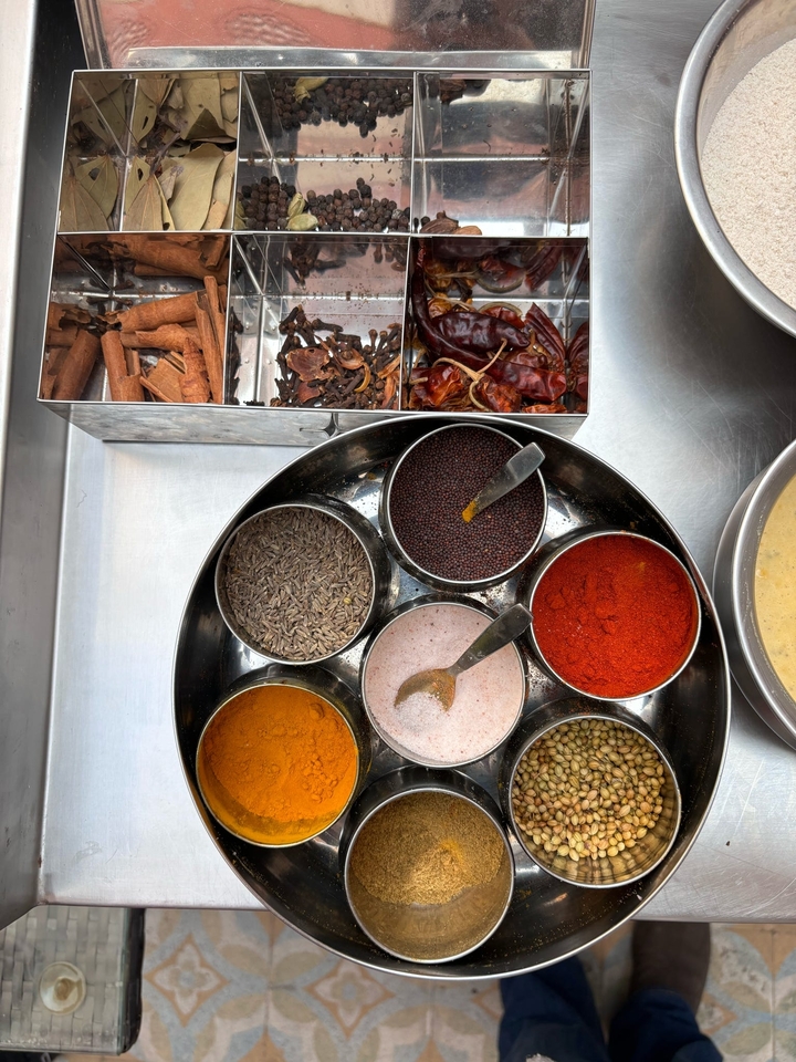 Gros plan d'un récipient à épices contenant diverses épices comme le cumin et les graines de moutarde.