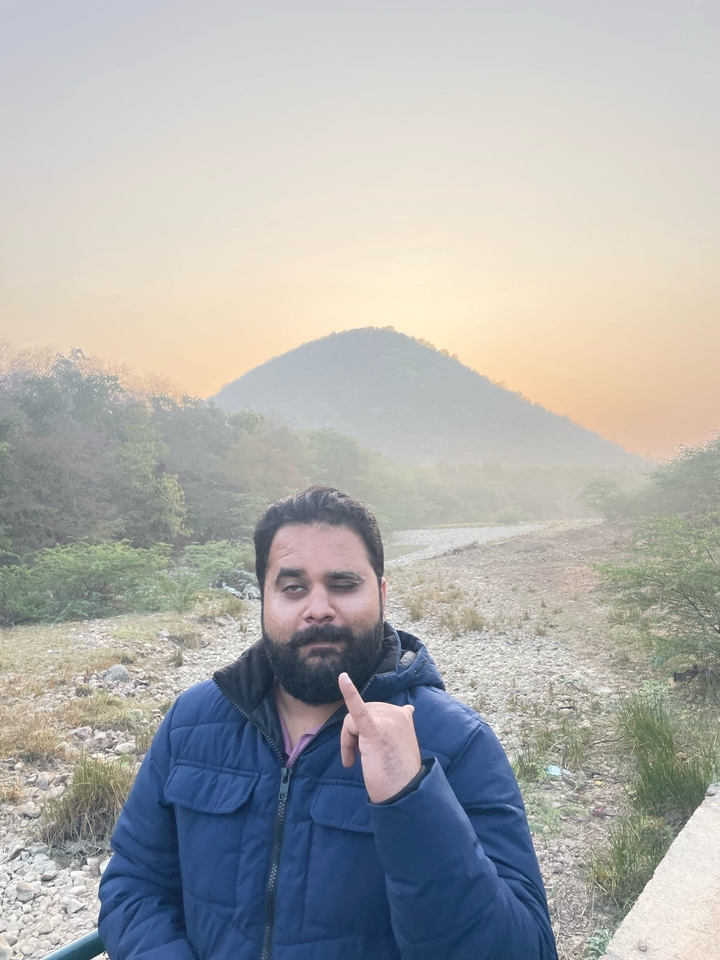 Personne debout près d'une montagne pendant le coucher du soleil.
