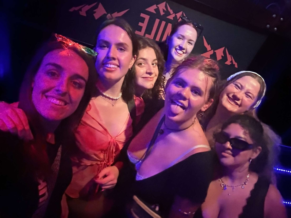 Groupe d'amis posant dans un club avec des néons