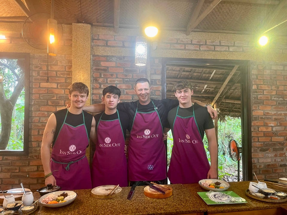 Groupe d'amis en tabliers de cuisine posant dans une cuisine.