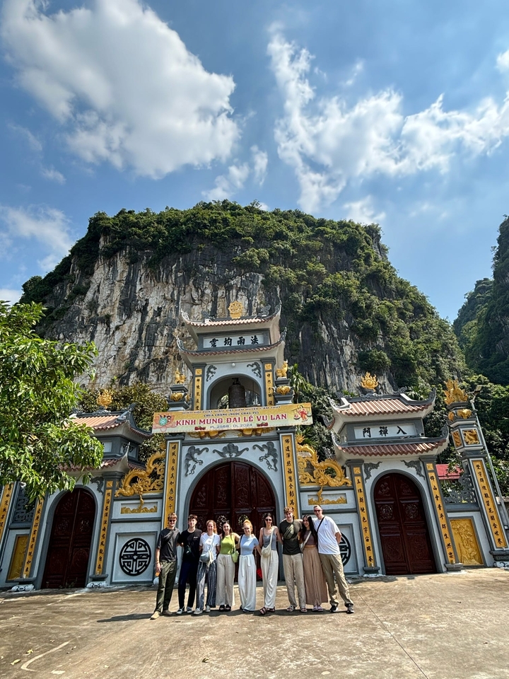 Tempeleingang mit detaillierter Architektur und felsigen Hügeln im Hintergrund.