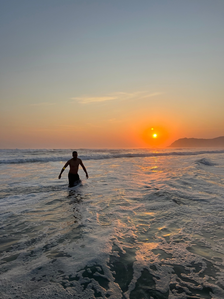 Personne marchant dans la mer avec un magnifique coucher de soleil.