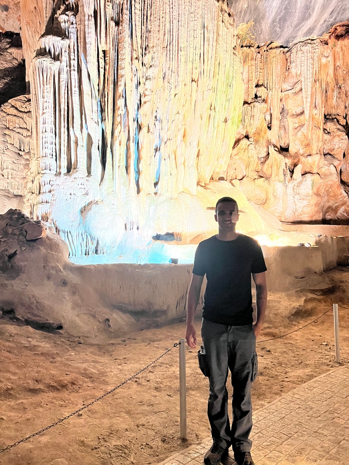 Personne qui pose dans une grotte bien éclairée.