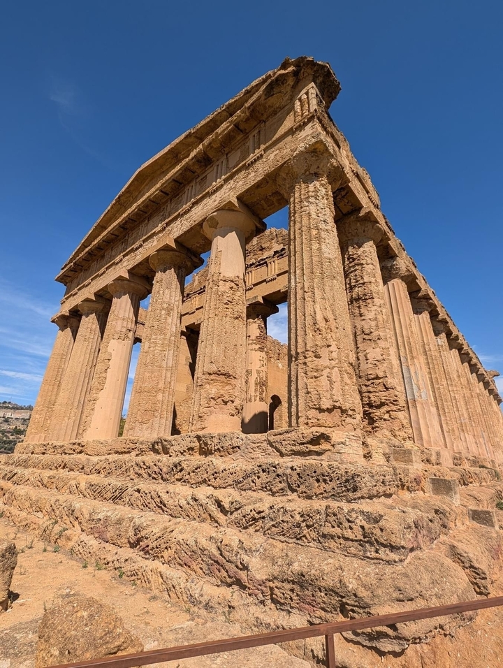 Temple ancien avec des colonnes et ciel bleu.