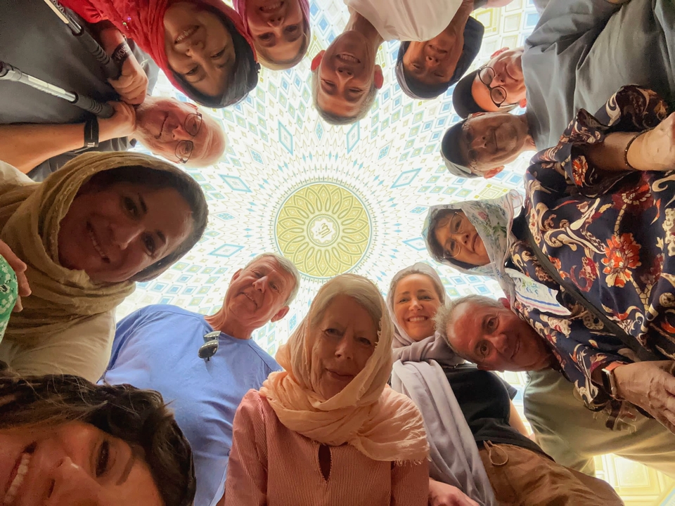 Grupo mirando hacia arriba al interior de una cúpula decorada.
