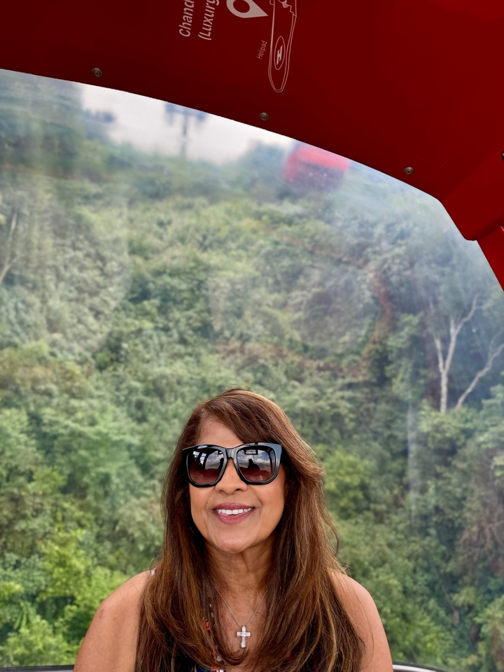 Personne souriante avec un arrière-plan forestier.