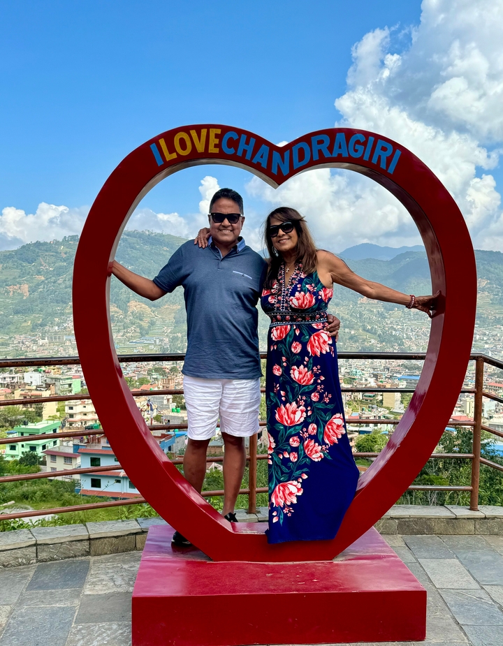 "Couple posant avec une vue panoramique derrière."