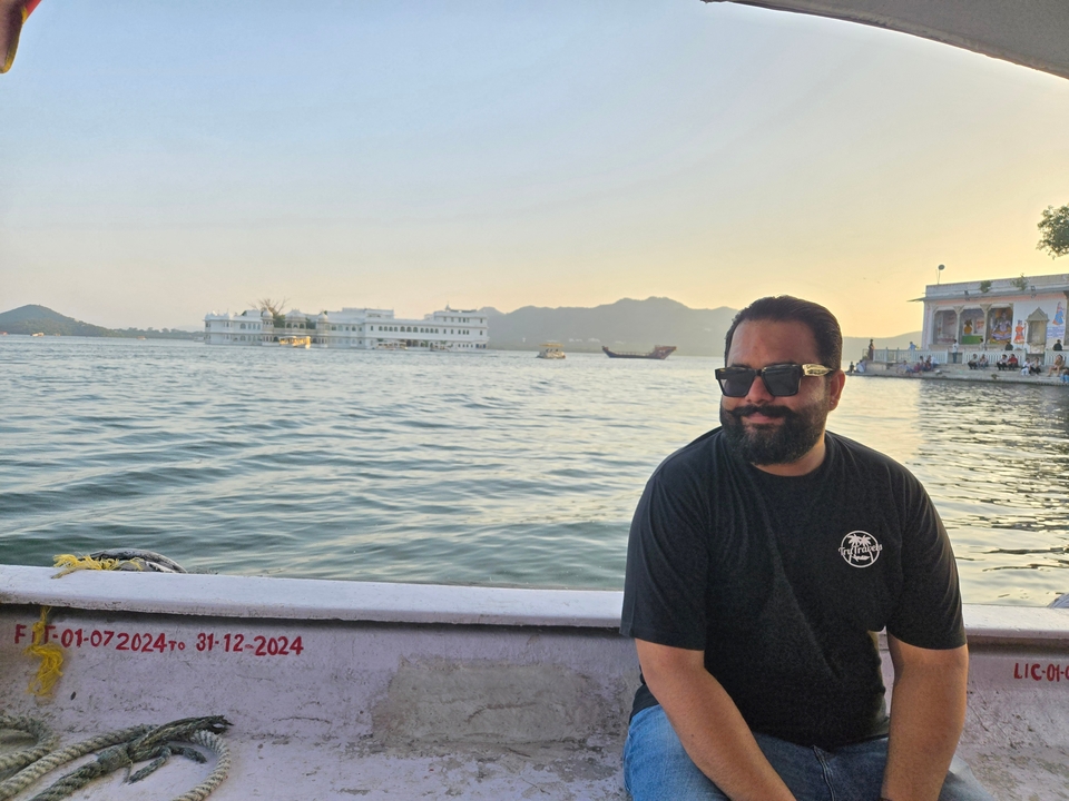 Un homme avec des lunettes de soleil sur un bateau avec un lac pittoresque en arrière-plan.