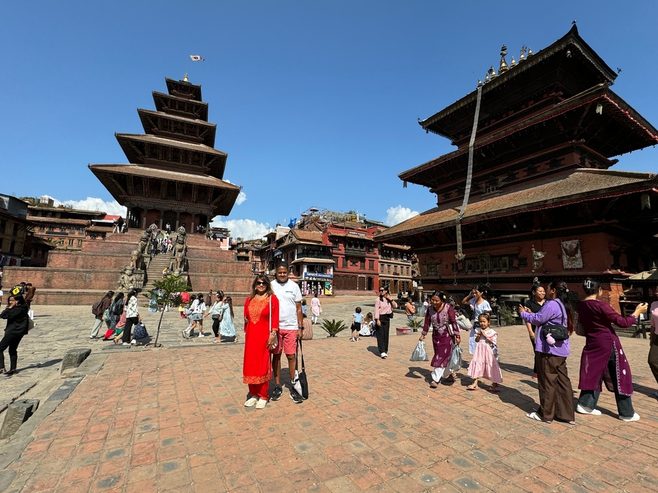 Des gens se promenant sur une place historique avec une architecture traditionnelle.