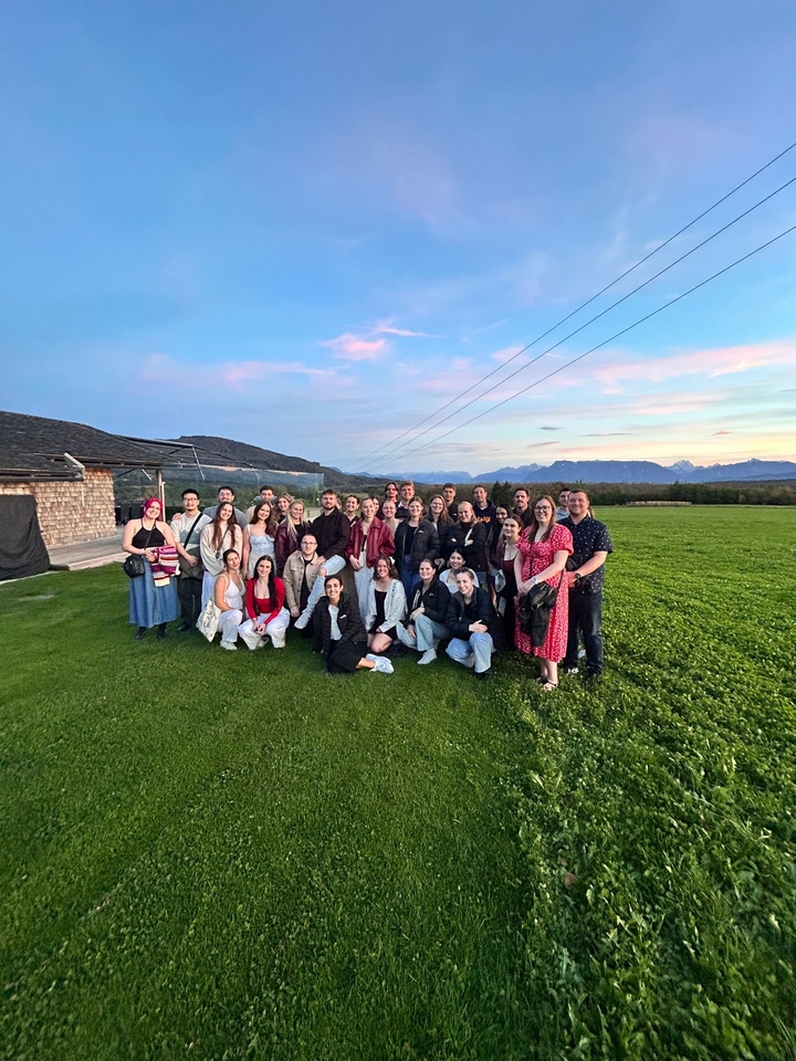 Grand groupe de personnes posant devant un décor pittoresque.
