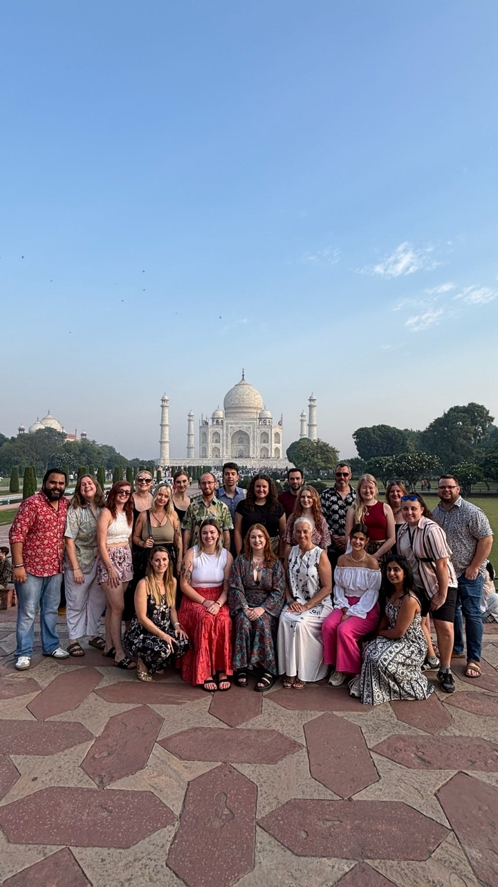 Groupe de touristes posant devant le Taj Mahal.