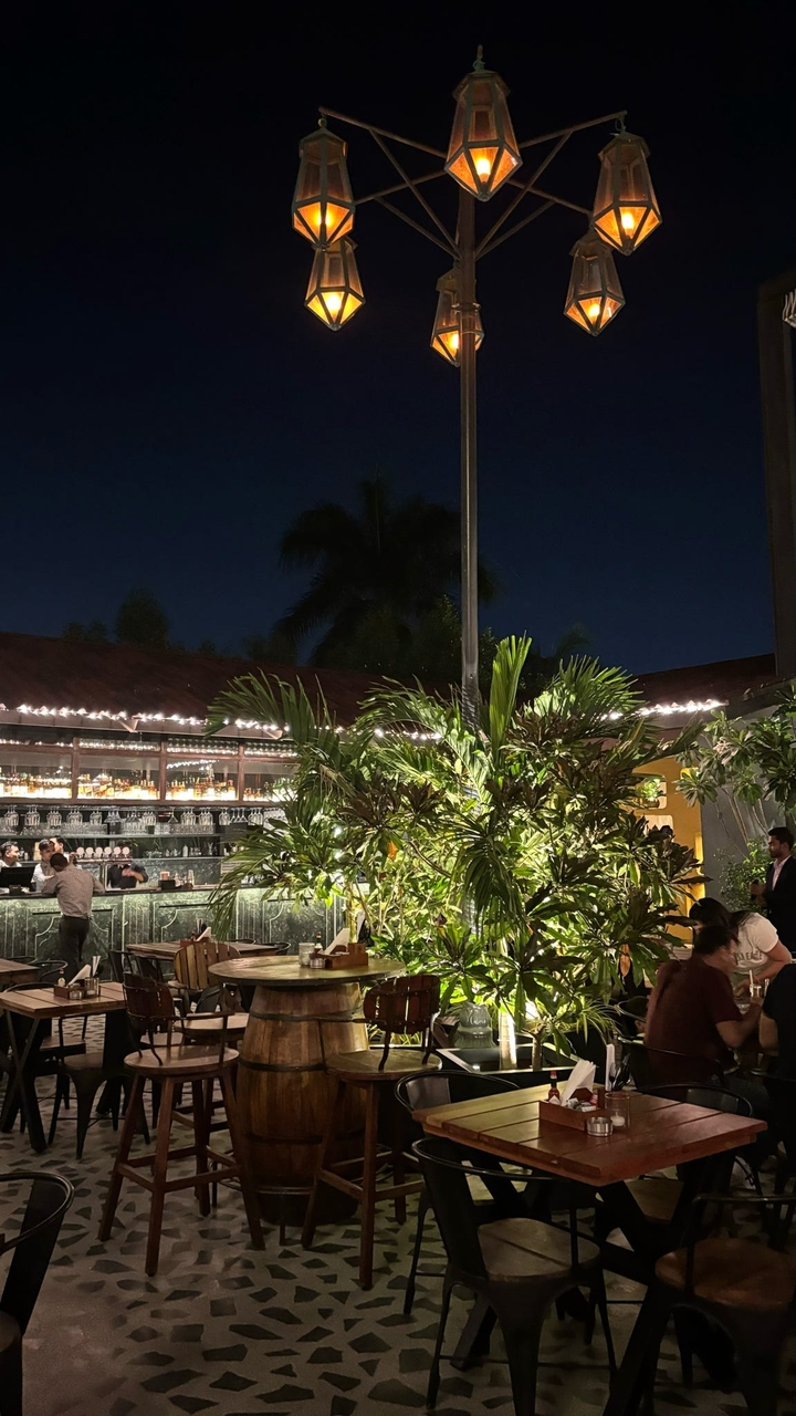 Bar extérieur pendant la nuit avec guirlandes lumineuses.