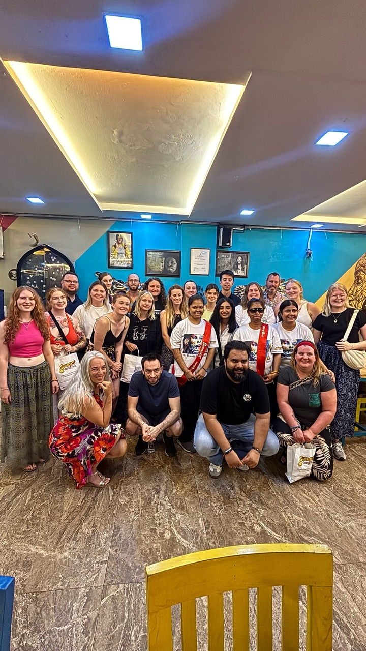 Groupe d'amis posant ensemble à l'intérieur.