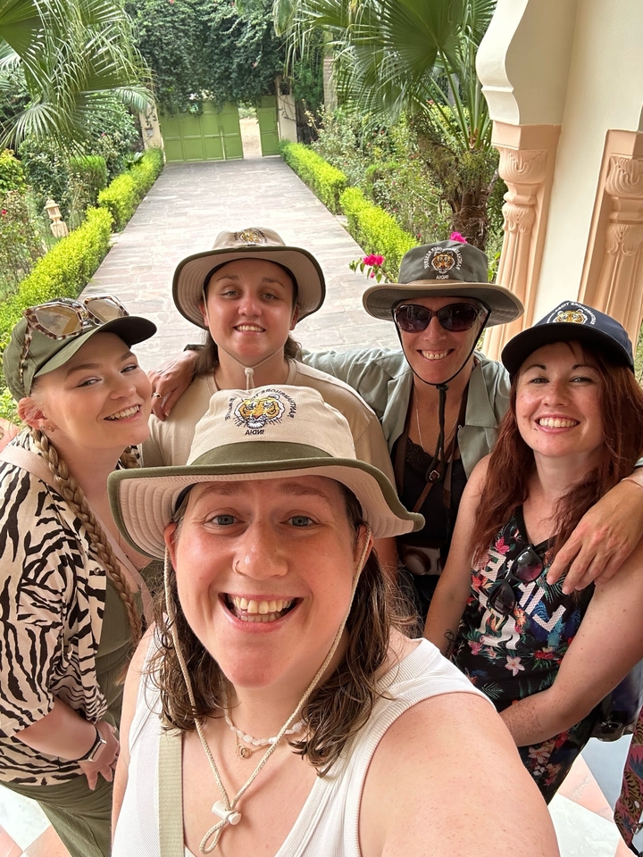 Groupe de femmes portant des chapeaux posant ensemble.