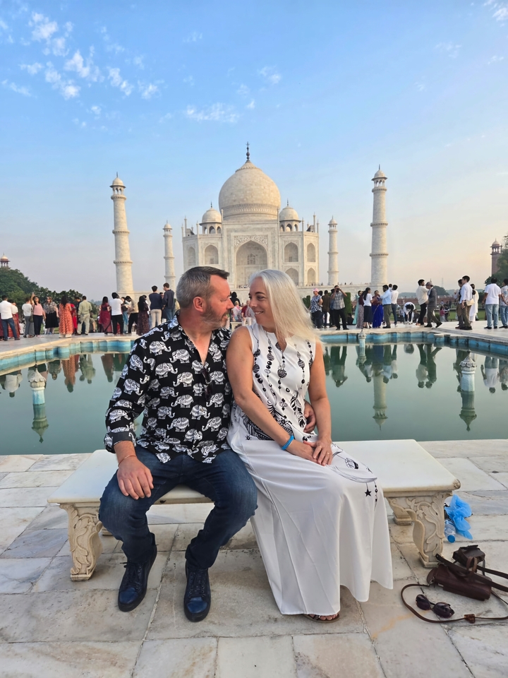 Couple assis devant le Taj Mahal.