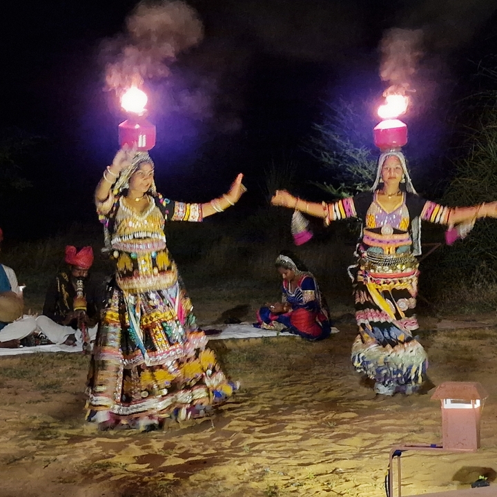 Danseurs traditionnels se produisant la nuit avec des costumes colorés.